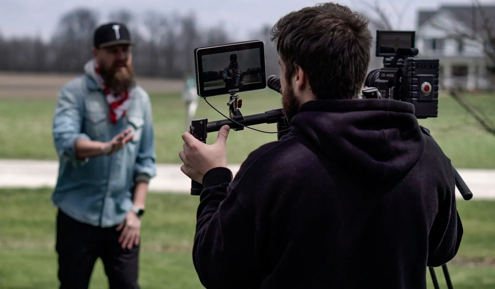 Açık havada gimbal ve monitörlü kamerayla bir kişiyi çeken ekip