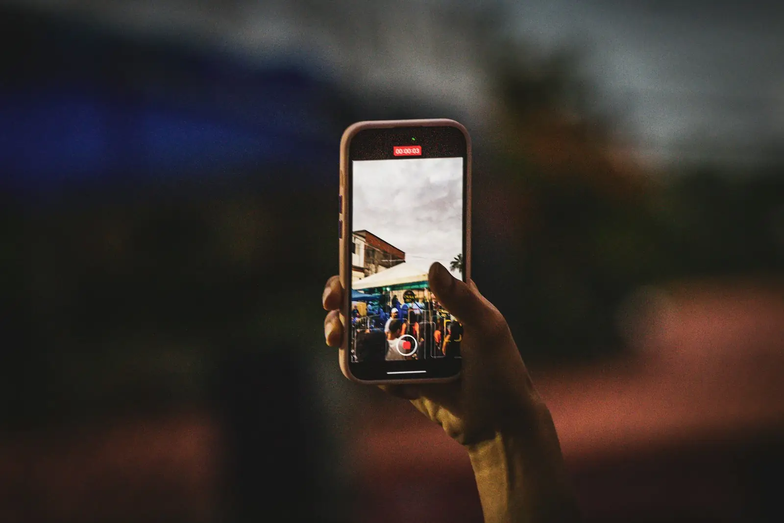 Karanlık bir ortamda telefonla fotoğraf çeken el
