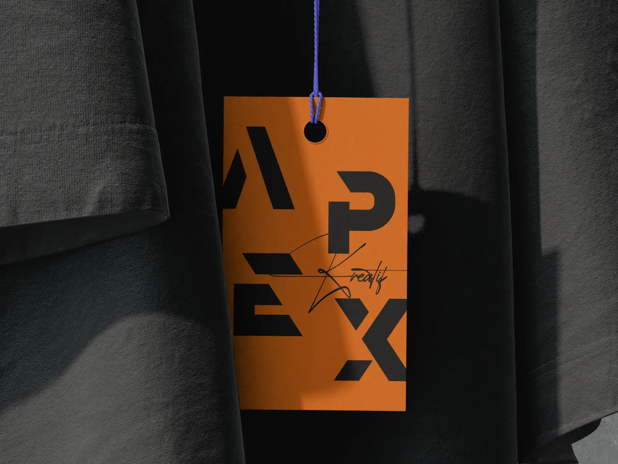 Orange Apex Kreatif label hanging between black fabrics