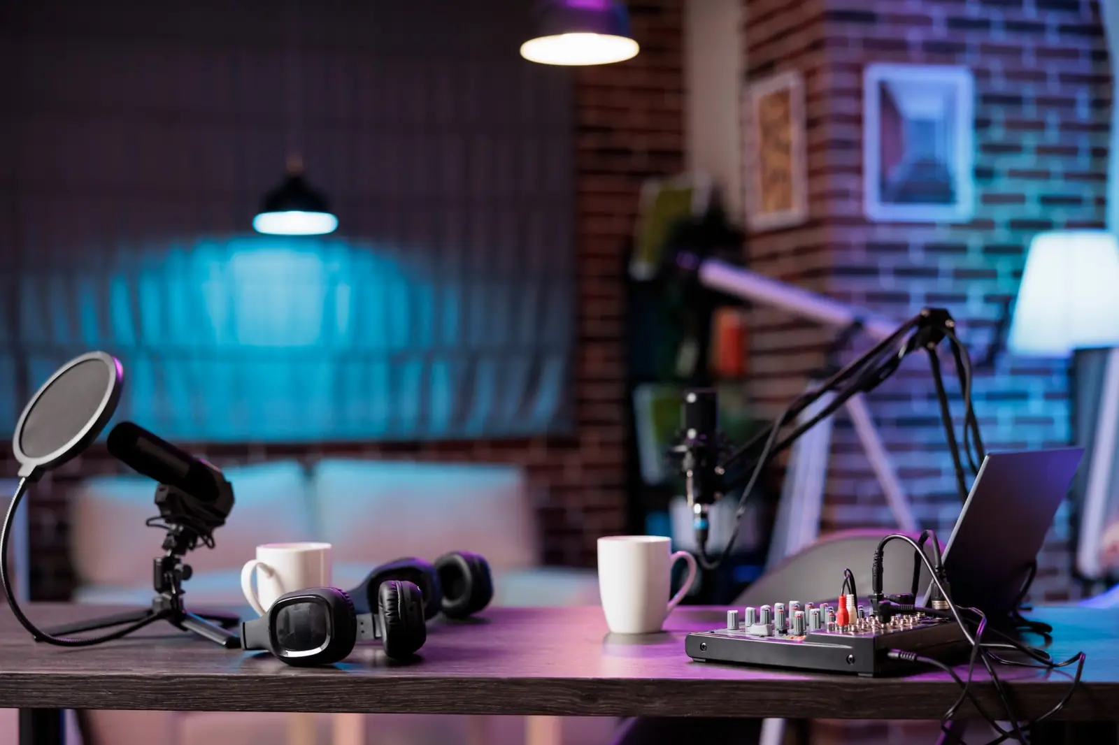Podcast and filming studio set up with microphones, headphones and a mixer